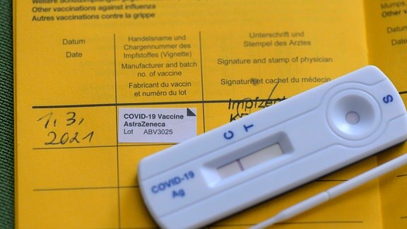 Ein Streifen: Test ist negativ. Selbsttest auf einem Impfpass. 