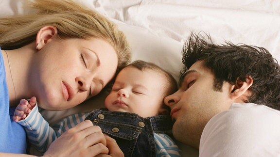 Eine junge Familie schläft gemeinsam
