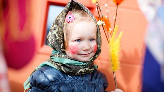 Kleines Mädchen im Freien, das Schokoladeneier als Teil der Ostertradition in Finnland sammelt