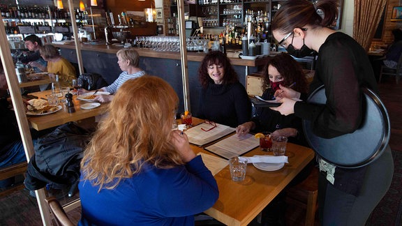 Frauen essen in einem Restaurant in Coronazeiten