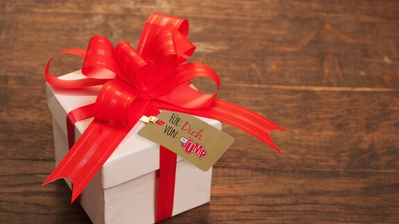 Ein hellbraun eingepacktes Geschenk mit roter Schleife