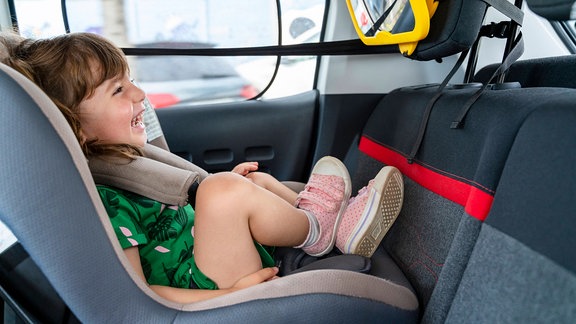 Lachendes Kind im Kindersitz im Auto