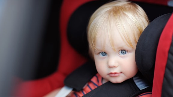 Kleinkind sitzt in einem Kindersitz in einem Auto