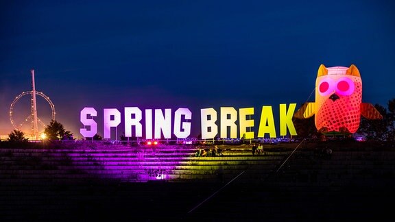 Der Schriftzug "Spring Break" ist in verschiedenfarbigen Lichtern zu sehen.