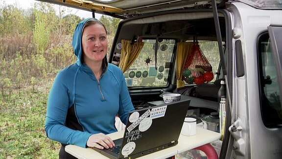 Eine Frau arbeitet im freien mit dem Computer
