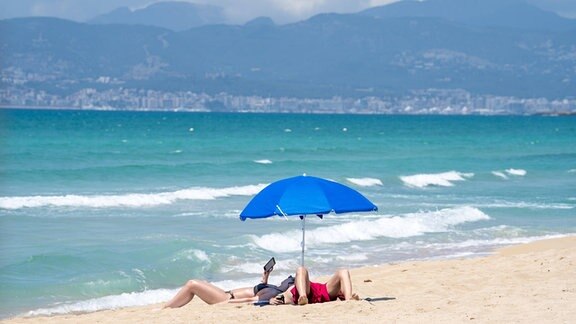Vor dem Neustart nach dem Corona-Lockdown: Touristen am fast leeren Strand auf Mallorca am Playa de Palma